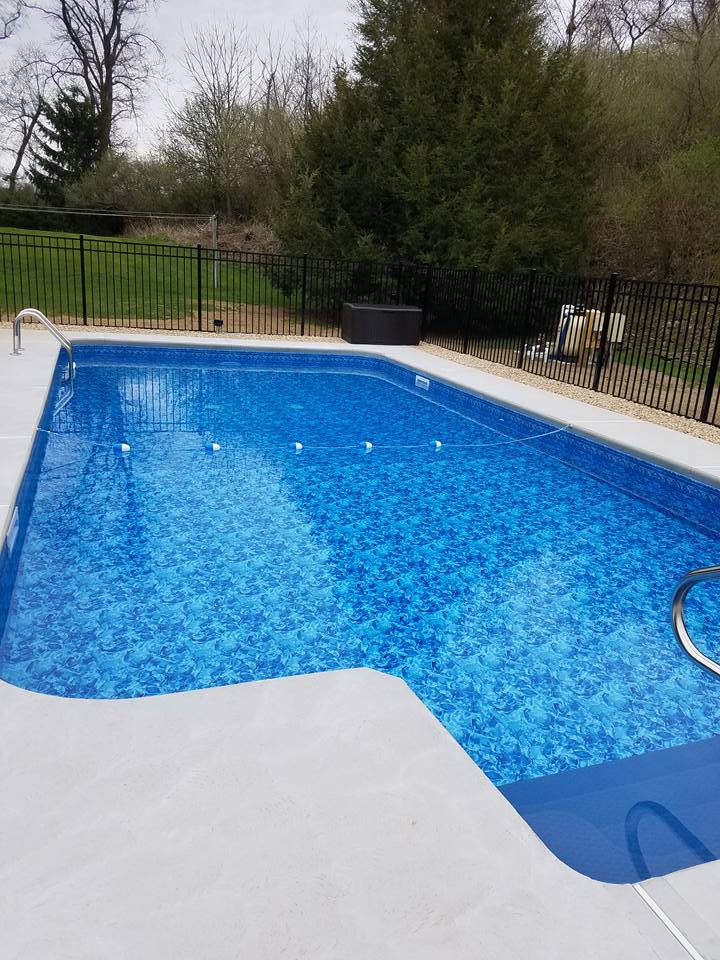 Chontos custom inground pool installation with fencing and stone coping by Ahner Pools