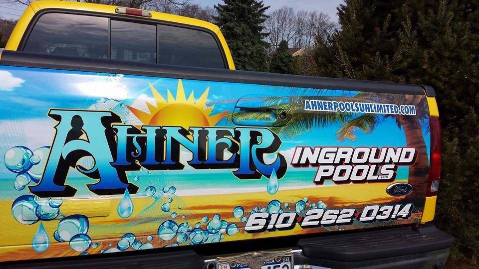 Ahner Pools branded yellow work truck on a residential job site in the Lehigh Valley