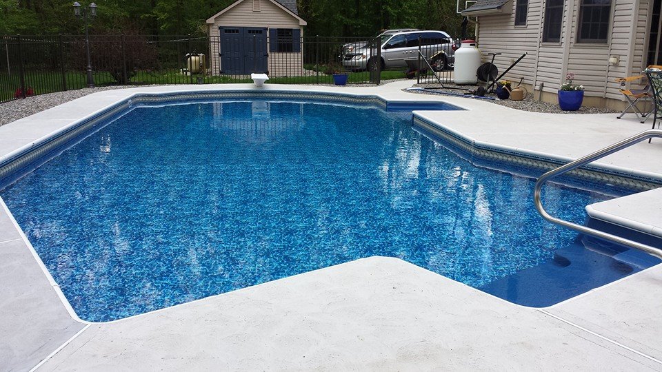 Custom shaped inground pool with decorative stonework by Ahner Pools