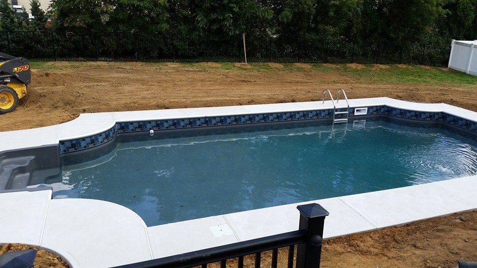 Rubi family backyard inground pool surrounded by green lawn and patio by Ahner Pools